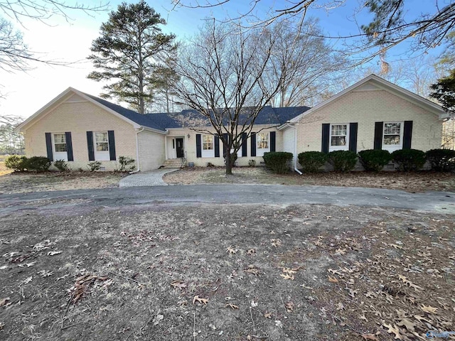 single story home featuring brick siding