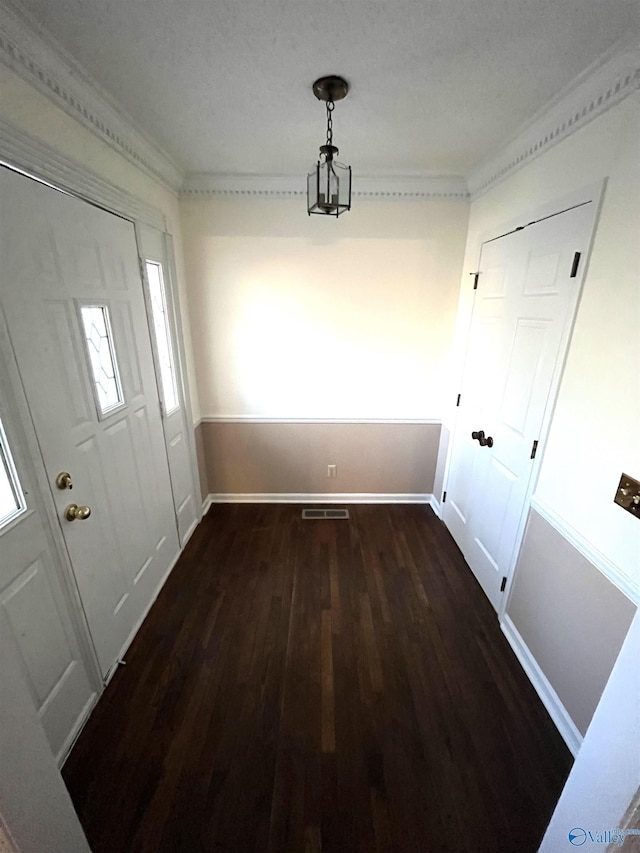 unfurnished dining area with baseboards, wood finished floors, and ornamental molding