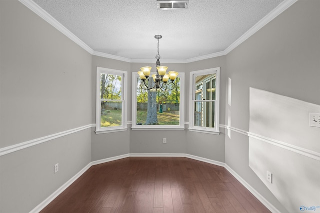 unfurnished dining area with ornamental molding, dark hardwood / wood-style flooring, a textured ceiling, and a chandelier