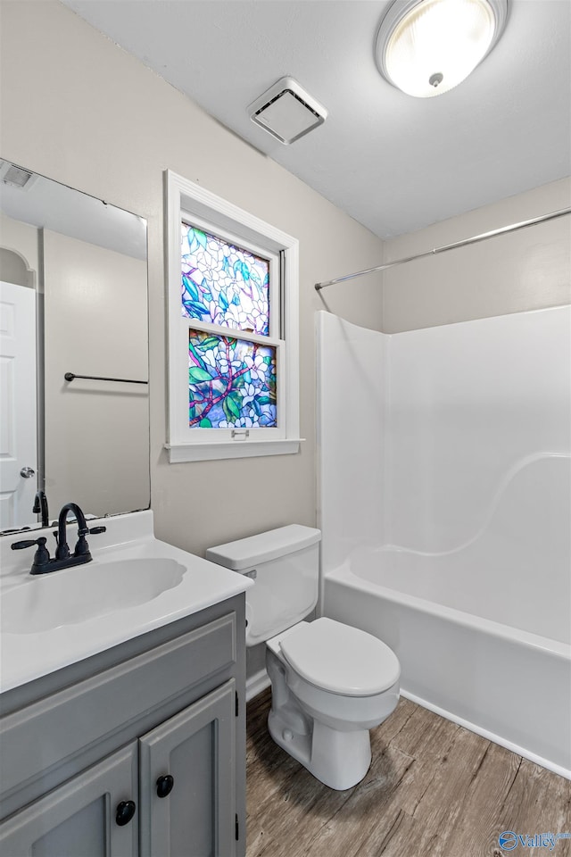 full bathroom with toilet, vanity, hardwood / wood-style floors, and  shower combination