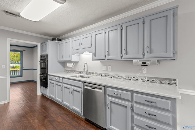 kitchen featuring dark wood-type flooring, dishwasher, sink, ornamental molding, and double oven