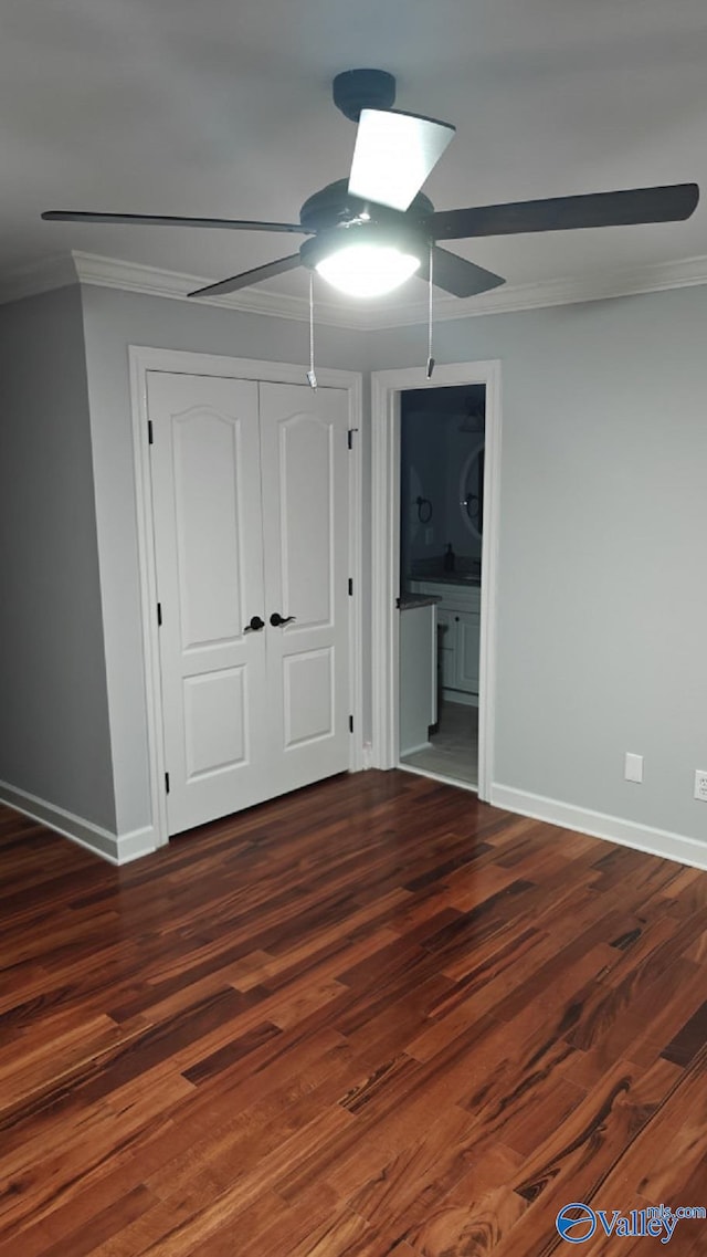 unfurnished bedroom with dark wood-type flooring, connected bathroom, ornamental molding, a closet, and ceiling fan