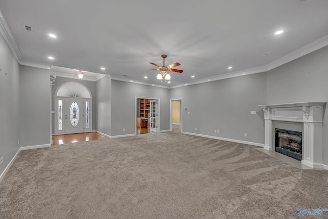 unfurnished living room featuring crown molding, ceiling fan, and light colored carpet