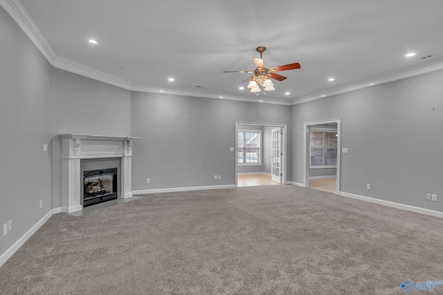 unfurnished living room with ceiling fan, ornamental molding, and light carpet