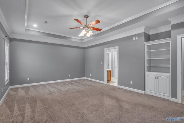 unfurnished bedroom featuring ceiling fan, ornamental molding, and a tray ceiling