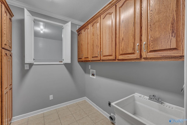 laundry area with cabinets, sink, crown molding, hookup for a washing machine, and a textured ceiling