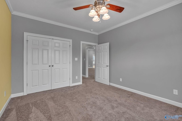 unfurnished bedroom featuring carpet flooring, ceiling fan, a closet, and ornamental molding