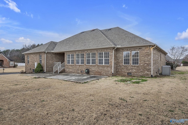 back of property featuring central AC unit, a patio area, and a yard