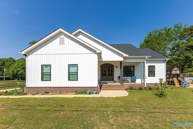 modern inspired farmhouse featuring a front lawn, board and batten siding, and french doors