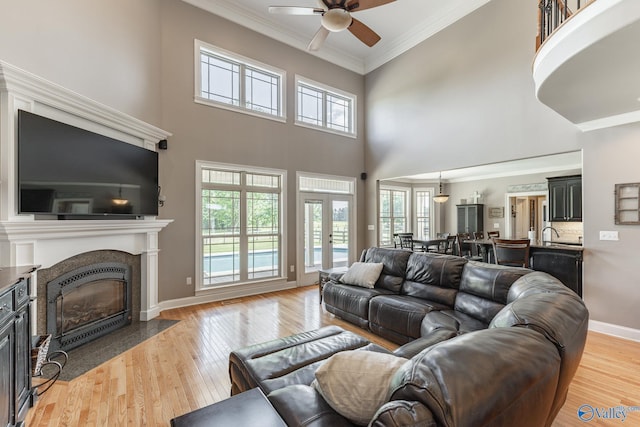 14690 Birchbark St, Athens, AL 35613 - living room featuring crown molding, ceiling fan, a fireplace with flush hearth, and a healthy amount of sunlight