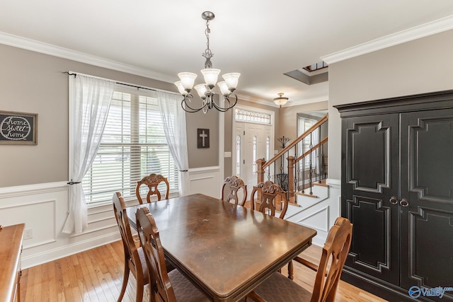 14690 Birchbark St, Athens, AL 35613 - dining room with a wainscoted wall, a chandelier, ornamental molding, stairs, and light wood-style flooring