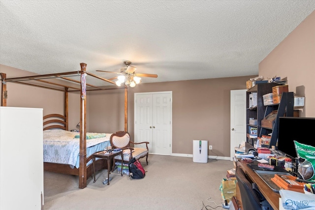 carpeted bedroom with a textured ceiling, ceiling fan, and a closet