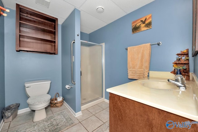 bathroom with tile patterned flooring, a paneled ceiling, a shower with door, vanity, and toilet