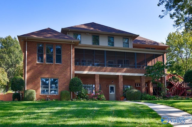 view of front of home with a sunroom and a front lawn