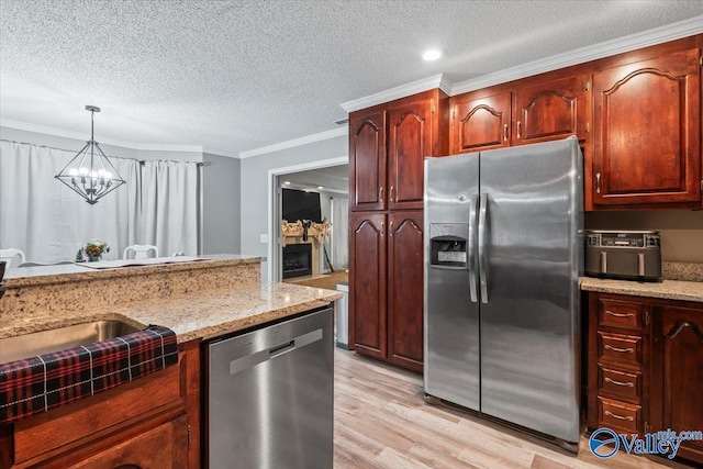 kitchen with ornamental molding, stainless steel appliances, a notable chandelier, light hardwood / wood-style floors, and hanging light fixtures