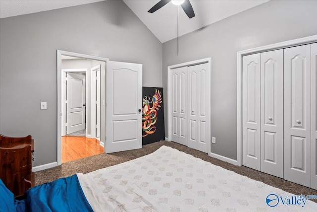 bedroom with multiple closets, ceiling fan, lofted ceiling, and dark colored carpet