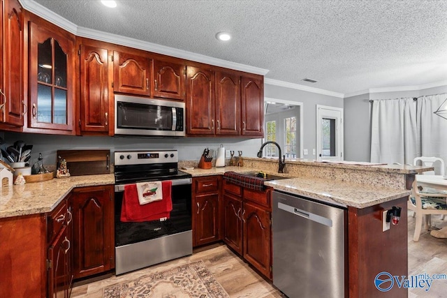 kitchen featuring sink, light wood-type flooring, ornamental molding, appliances with stainless steel finishes, and kitchen peninsula