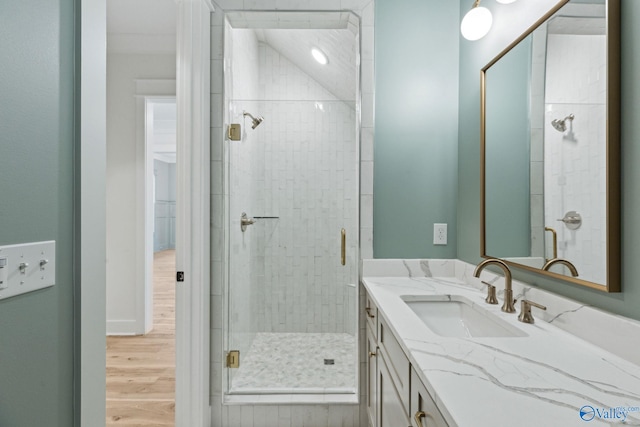 bathroom featuring hardwood / wood-style flooring, vanity, an enclosed shower, and crown molding