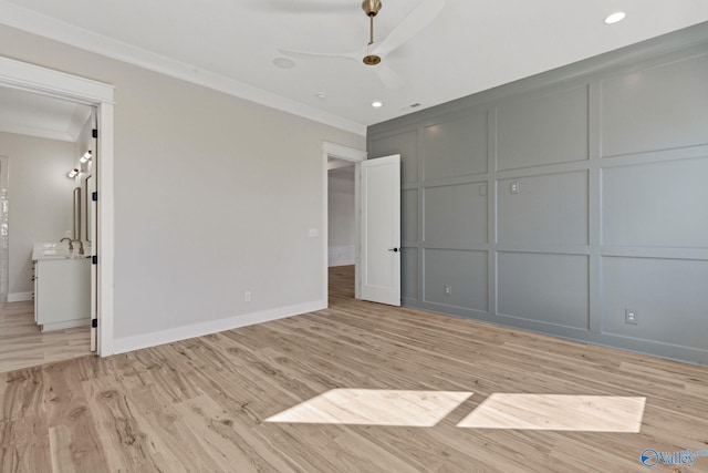 unfurnished bedroom featuring crown molding, sink, and light hardwood / wood-style floors