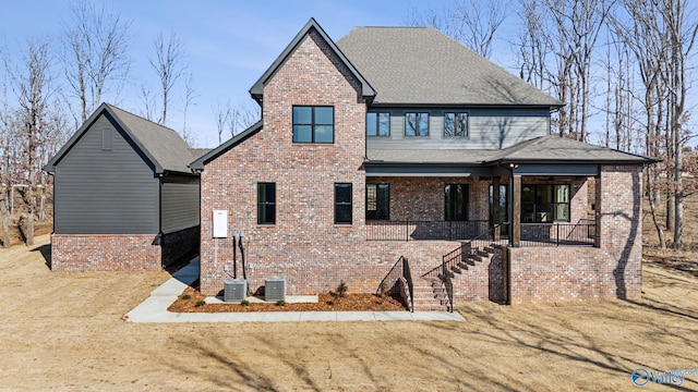 view of front facade featuring central AC, a front yard, and a porch