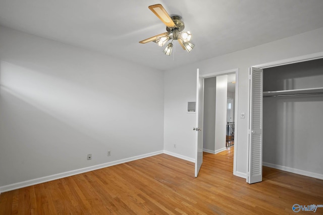 unfurnished bedroom with light wood-style floors, a closet, baseboards, and a ceiling fan