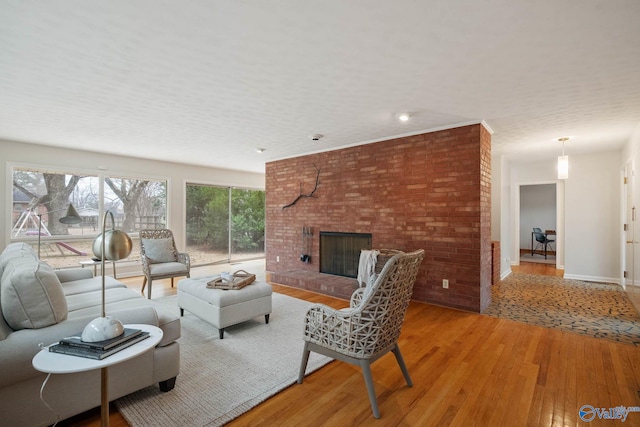 living room featuring a brick fireplace and wood finished floors