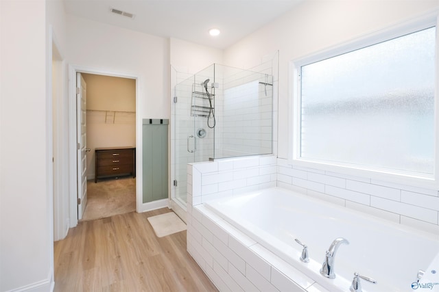 bathroom with hardwood / wood-style flooring and plus walk in shower