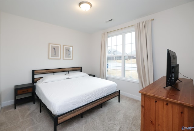 bedroom with light carpet and multiple windows