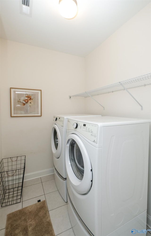 clothes washing area featuring separate washer and dryer and light tile patterned flooring