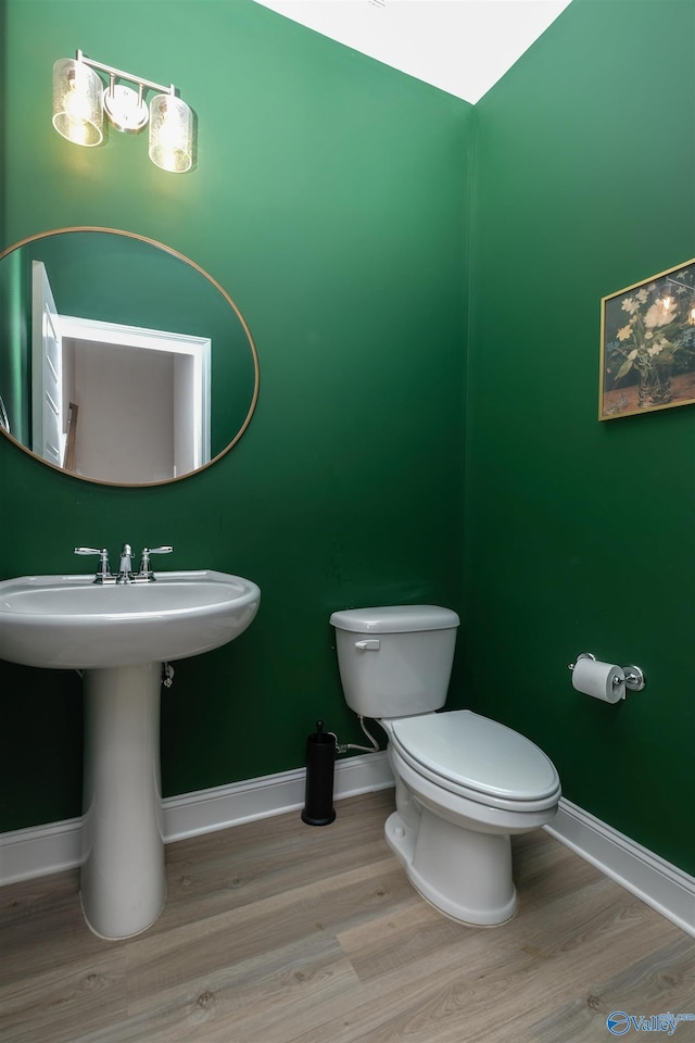 bathroom with toilet, wood-type flooring, and sink