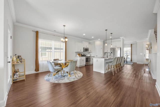 dining space featuring sink, dark wood-type flooring, and crown molding