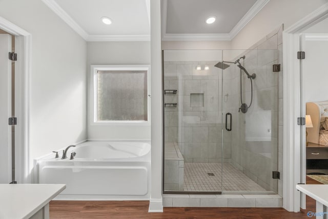 bathroom featuring crown molding, hardwood / wood-style flooring, and plus walk in shower