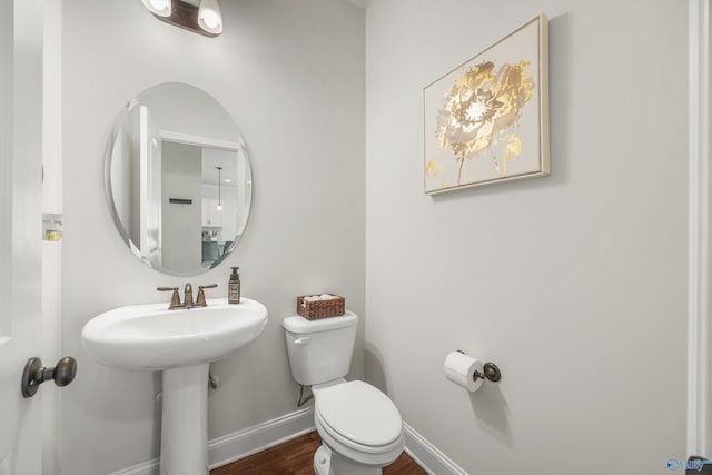 bathroom featuring wood-type flooring and toilet