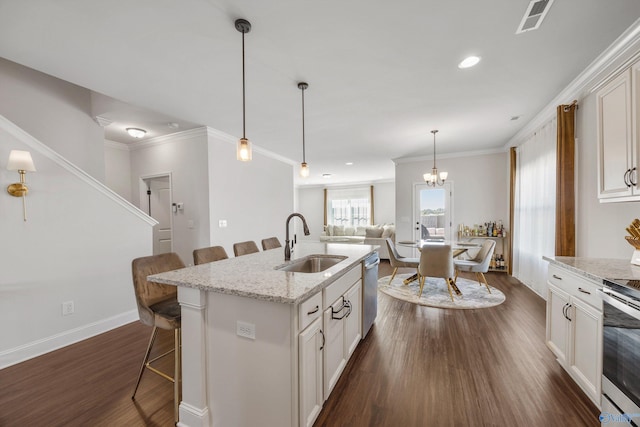 kitchen featuring a center island with sink, sink, a kitchen bar, light stone counters, and dark hardwood / wood-style floors