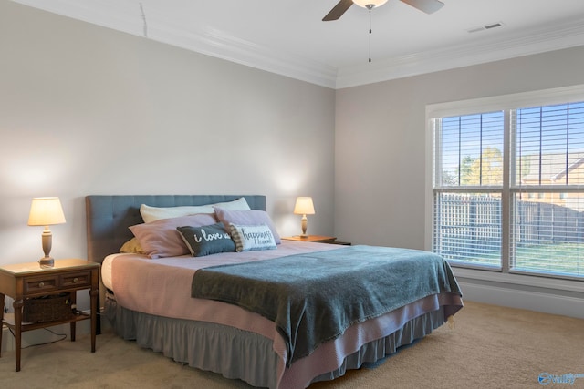 carpeted bedroom with ornamental molding, visible vents, and a ceiling fan