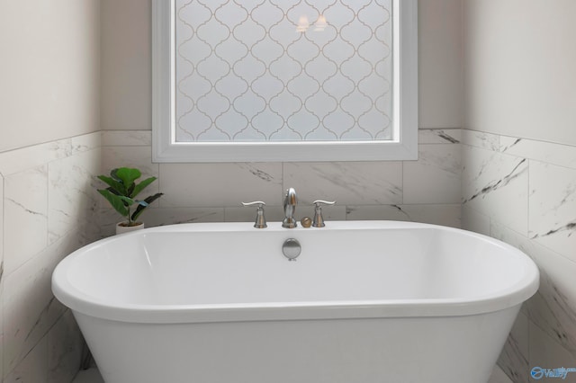 bathroom featuring a soaking tub and tile walls