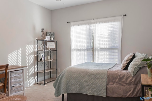 bedroom featuring light colored carpet and baseboards