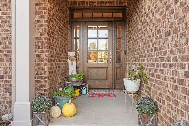 doorway to property featuring brick siding