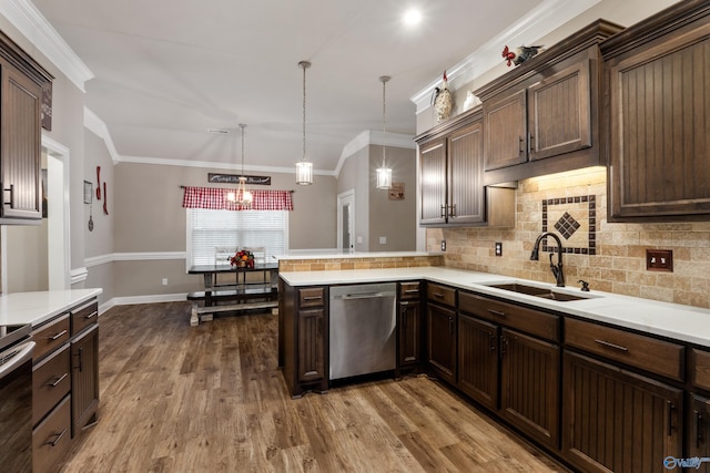 kitchen with dishwasher, sink, ornamental molding, decorative light fixtures, and kitchen peninsula