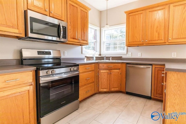 kitchen featuring pendant lighting, stainless steel appliances, and light tile patterned floors