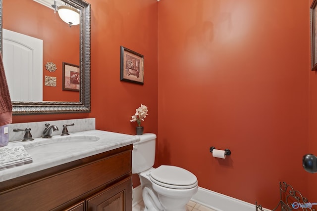 bathroom with tile patterned floors, baseboards, vanity, and toilet