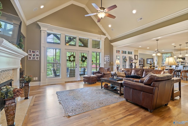 living area featuring high vaulted ceiling, visible vents, plenty of natural light, and a fireplace