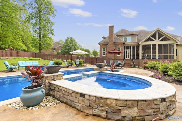 view of pool featuring a patio, a fenced backyard, a sunroom, a fenced in pool, and an in ground hot tub