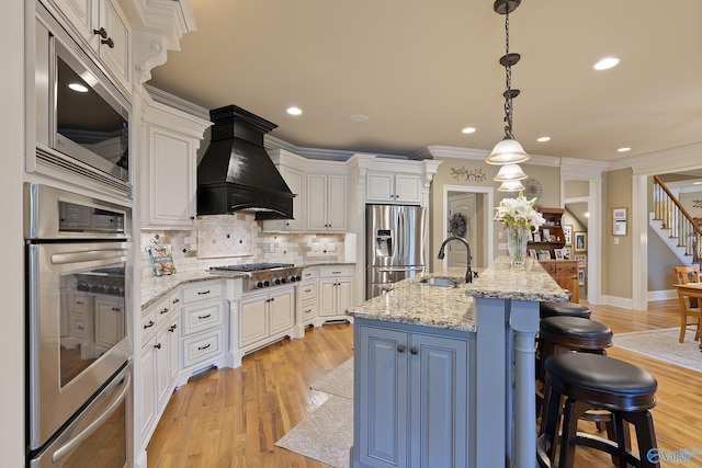 kitchen featuring a sink, white cabinetry, appliances with stainless steel finishes, and custom exhaust hood