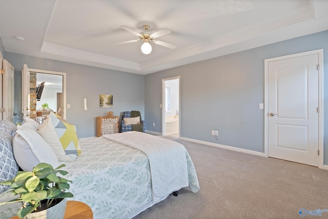 carpeted bedroom with connected bathroom, a tray ceiling, ceiling fan, and crown molding