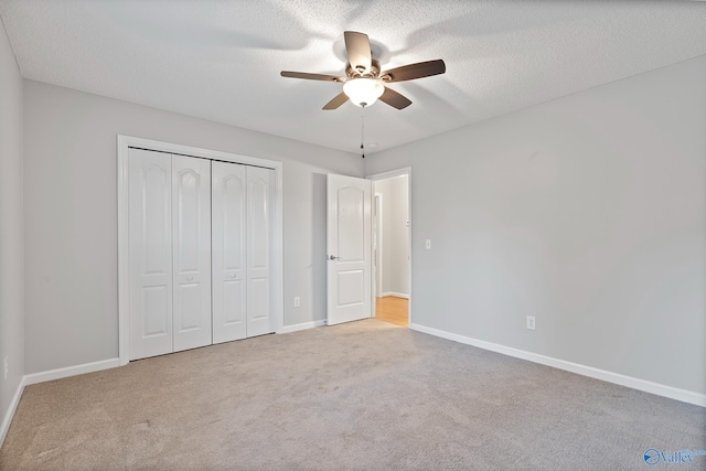 unfurnished bedroom with a closet, light colored carpet, and ceiling fan