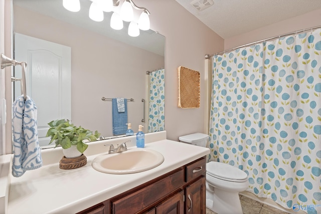 bathroom featuring vanity, tile patterned floors, a textured ceiling, and toilet