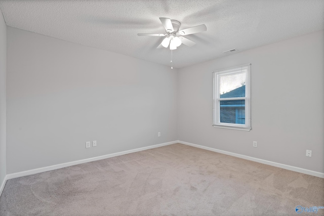 carpeted empty room featuring a textured ceiling and ceiling fan