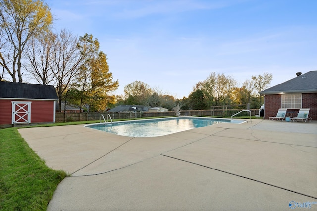 view of pool with a patio area and a storage shed