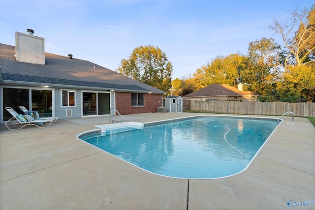 view of swimming pool featuring a patio area, a shed, and central AC